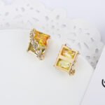 Wholesale gold leaf earrings with two-toned yellow rectangular CZ stones from junejewelry.com – unique fashion jewelry for bulk orders.