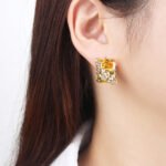 Wholesale gold leaf earrings with two-toned yellow rectangular CZ stones from junejewelry.com – unique fashion jewelry for bulk orders.