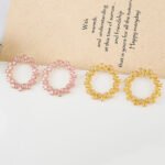 Wholesale pink zircon earrings with a circular design, platinum-plated copper, and 925 silver needles from JuneJewelry.com.