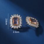 Wholesale blue gemstone earrings with a zircon sunburst on rhodium plated copper and 925 sterling silver pins from JuneJewelry.com – elegant fashion jewelry for bulk orders.