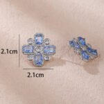 Wholesale blue zircon cross earrings with rectangular and round cubic zirconia stones, platinum plated on a copper base with a 925 silver needle, from JuneJewelry.com.