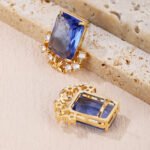 Wholesale blue zircon flower earrings with a rectangular blue stone and a floral design with white cubic zirconia, platinum plated with a 925 silver needle, from JuneJewelry.com.