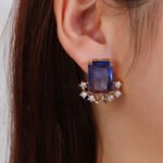 Wholesale blue zircon flower earrings with a rectangular blue stone and a floral design with white cubic zirconia, platinum plated with a 925 silver needle, from JuneJewelry.com.