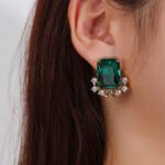 Wholesale blue zircon flower earrings with a rectangular blue stone and a floral design with white cubic zirconia, platinum plated with a 925 silver needle, from JuneJewelry.com.