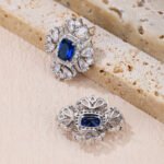 Wholesale ruby red gemstone earrings with a clear zircon cluster on rhodium plated copper and 925 sterling silver pins from JuneJewelry.com – elegant fashion jewelry for bulk orders.