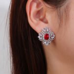 Wholesale ruby red gemstone earrings with a clear zircon cluster on rhodium plated copper and 925 sterling silver pins from JuneJewelry.com – elegant fashion jewelry for bulk orders.