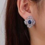 Wholesale ruby red gemstone earrings with a clear zircon cluster on rhodium plated copper and 925 sterling silver pins from JuneJewelry.com – elegant fashion jewelry for bulk orders.