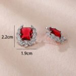 Wholesale zircon leaf earrings with a central red stone and a leaf motif with white cubic zirconia, platinum plated on a copper base with a 925 silver needle, from JuneJewelry.com.