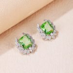 Wholesale zircon leaf earrings with a central red stone and a leaf motif with white cubic zirconia, platinum plated on a copper base with a 925 silver needle, from JuneJewelry.com.