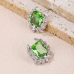 Wholesale zircon leaf earrings with a central red stone and a leaf motif with white cubic zirconia, platinum plated on a copper base with a 925 silver needle, from JuneJewelry.com.