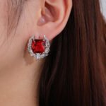 Wholesale zircon leaf earrings with a central red stone and a leaf motif with white cubic zirconia, platinum plated on a copper base with a 925 silver needle, from JuneJewelry.com.