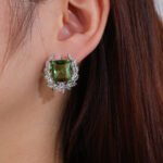 Wholesale zircon leaf earrings with a central red stone and a leaf motif with white cubic zirconia, platinum plated on a copper base with a 925 silver needle, from JuneJewelry.com.