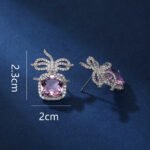 Wholesale zircon bow earrings with a cushion-cut pink center stone and cubic zirconia accents, platinum plated with a 925 silver needle, from JuneJewelry.com.