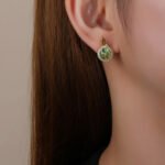 Wholesale lemon slice earrings with bright yellow and green zircon stones, a gold-plated copper base, and a 925 silver needle from JuneJewelry.com.