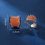 Wholesale Colorful Statement Earrings with a gold plated finish and orange and blue cubic zirconia stones from JuneJewelry.com – unique fashion jewelry for bulk orders.