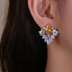 Wholesale Cubic Zirconia Stud Earrings with a central pear-shaped stone and silver plating from JuneJewelry.com – elegant and unique jewelry for bulk orders.