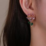 Wholesale Dangle Flower Stud Earrings with a gold plated finish and pink and green cubic zirconia stones from JuneJewelry.com – unique fashion jewelry for bulk orders.