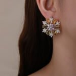 Wholesale Pink Flower Stud Earrings with a gold plated finish and pink and clear cubic zirconia stones from JuneJewelry.com – unique fashion jewelry for bulk orders.