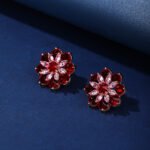 Wholesale Red Flower Stud Earrings with a gold plated finish and ruby red cubic zirconia stones from JuneJewelry.com – unique fashion jewelry for bulk orders.
