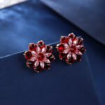 Wholesale Red Flower Stud Earrings with a gold plated finish and ruby red cubic zirconia stones from JuneJewelry.com – unique fashion jewelry for bulk orders.