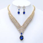 Wholesale platinum plated necklace set with cubic zirconia stones. Elegant brass V-shaped necklace and matching drop earrings for formal wear.