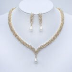 Wholesale platinum plated set with pearl and zirconia. Brass V-shaped necklace and matching leaf-design earrings for bridal wear.