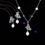 Abalone Shell Butterfly Pearl Jewelry Set in gold plating. The necklace and drop earrings feature a butterfly pendant with rainbow abalone shell wings and a dangling baroque freshwater pearl.