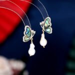 Abalone Shell Butterfly Pearl Jewelry Set in gold plating. The necklace and drop earrings feature a butterfly pendant with rainbow abalone shell wings and a dangling baroque freshwater pearl.