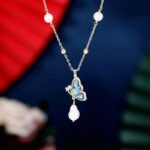Abalone Shell Butterfly Pearl Jewelry Set in gold plating. The necklace and drop earrings feature a butterfly pendant with rainbow abalone shell wings and a dangling baroque freshwater pearl.