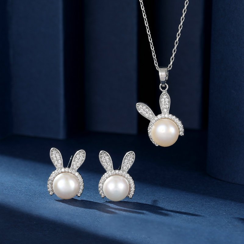 Wholesale Cute Rabbit Pearl Set in two colors: white gold and yellow gold. Both sets feature a white imitation pearl with a micro-pave Cubic Zirconia bunny ear design for the pendant and matching stud earrings.