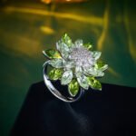 Wholesale Green Gradient Crystal Flower Ring and Stud Earrings Set. Features light green and peridot-colored marquise-cut zircons/crystals set in 18K white gold plated copper.