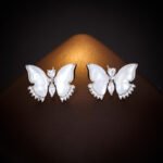 Wholesale Butterfly Shell Jewelry Set shown in gold and silver colors. The elegant set includes a butterfly pendant necklace, stud earrings, and an adjustable ring, all featuring iridescent Mother of Pearl wings and micro-paved Cubic Zirconia accents.