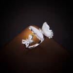 Wholesale Butterfly Shell Jewelry Set shown in gold and silver colors. The elegant set includes a butterfly pendant necklace, stud earrings, and an adjustable ring, all featuring iridescent Mother of Pearl wings and micro-paved Cubic Zirconia accents.