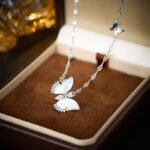 Wholesale Butterfly Shell Jewelry Set shown in gold and silver colors. The elegant set includes a butterfly pendant necklace, stud earrings, and an adjustable ring, all featuring iridescent Mother of Pearl wings and micro-paved Cubic Zirconia accents.