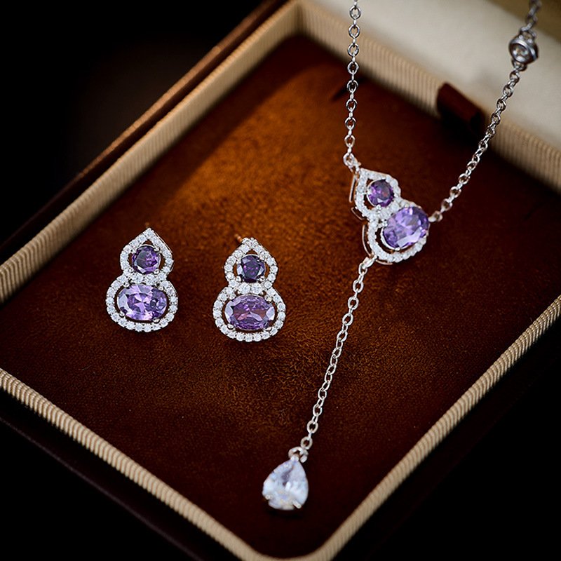 T-017 (3) Wholesale Purple Zircon Gourd Prosperity Set (Hulu shape), featuring copper plated with white gold, vibrant micro-pave purple zircon stones, gourd stud earrings, and a simple versatile neck chain, a light luxury set for spring/summer from junejewelry.com.