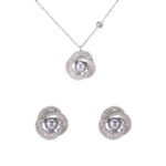 Wholesale Twist Knot Pearl CZ Set featuring a ring, stud earrings, and necklace pendant. Each piece showcases a dark gray pearl surrounded by a knot twist of micro-pave cubic zirconia baguette stones, set against a dark background in a jewelry box.