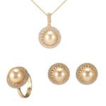 Wholesale Halo Pearl CZ Jewelry Set displayed in a box, showing a ring, stud earrings, and a pendant necklace. The design features a large round imitation pearl encircled by a halo of glittering cubic zirconia. Available in Golden Pearl/Yellow Gold and Black Pearl/Platinum finishes.