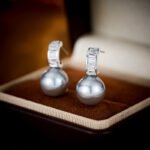 Wholesale Simple Baguette Pearl Set on a white background, featuring a necklace and drop earrings. Both pieces showcase a round dark gray pearl suspended from a rectangular bail fully paved with Baguette-Cut Cubic Zirconia.