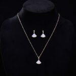 Wholesale Fan Shape Shell Set with natural Mother of Pearl fan motif and delicate CZ connector stones. The set includes a matching necklace and stud earrings, shown in both gold and platinum finishes on a black display.