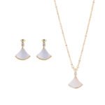 Wholesale Fan Shape Shell Set with natural Mother of Pearl fan motif and delicate CZ connector stones. The set includes a matching necklace and stud earrings, shown in both gold and platinum finishes on a black display.