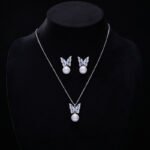 Wholesale Butterfly Pearl CZ Set in both white gold and yellow gold plating. Features a Micro-Pave CZ butterfly motif suspending a round imitation pearl, available as a necklace and matching earrings.