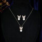 Wholesale Butterfly Pearl CZ Set in both white gold and yellow gold plating. Features a Micro-Pave CZ butterfly motif suspending a round imitation pearl, available as a necklace and matching earrings.