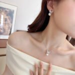 Wholesale Butterfly Pearl CZ Set in both white gold and yellow gold plating. Features a Micro-Pave CZ butterfly motif suspending a round imitation pearl, available as a necklace and matching earrings.