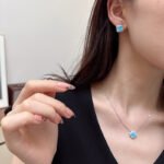 Wholesale Light Luxury Lucky Clover Turquoise Blue Set, featuring the four-leaf clover motif inlaid with vibrant turquoise blue stones, includes matching niche design earrings and a high-end sense necklace, from junejewelry.com.