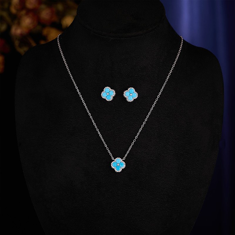 T-050 (2) Wholesale Light Luxury Lucky Clover Turquoise Blue Set, featuring the four-leaf clover motif inlaid with vibrant turquoise blue stones, includes matching niche design earrings and a high-end sense necklace, from junejewelry.com.