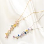 Wholesale Colorful Zircon Flower Tassel Jewelry Set in Dopamine style, featuring multi-colored inlaid zircon gemstones, a flower tassel necklace (choker/collar chain), and matching earrings, available in 18K Gold Plated or White Gold Plated copper from junejewelry.com.