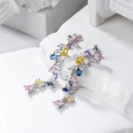 Wholesale Colorful Zircon Flower Tassel Jewelry Set in Dopamine style, featuring multi-colored inlaid zircon gemstones, a flower tassel necklace (choker/collar chain), and matching earrings, available in 18K Gold Plated or White Gold Plated copper from junejewelry.com.