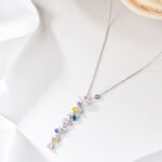 Wholesale Colorful Zircon Flower Tassel Jewelry Set in Dopamine style, featuring multi-colored inlaid zircon gemstones, a flower tassel necklace (choker/collar chain), and matching earrings, available in 18K Gold Plated or White Gold Plated copper from junejewelry.com.