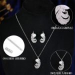 Wholesale Feather Pearl Zircon Set in a platinum-plated finish on a black display bust. Features a matching necklace and stud earrings, both in a curved feather shape paved with cubic zirconia, centered with a single white pearl.