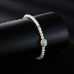 Wholesale Turquoise Pearl Beaded Set on a white background. Includes a long necklace with a round turquoise-colored pendant, matching gold-textured stud earrings, and an adjustable pearl slider bracelet.